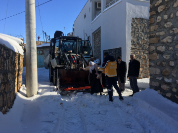 Kardan yolu kapanan mahallede hastalanan kadın, kepçeyle ambulansa taşındı